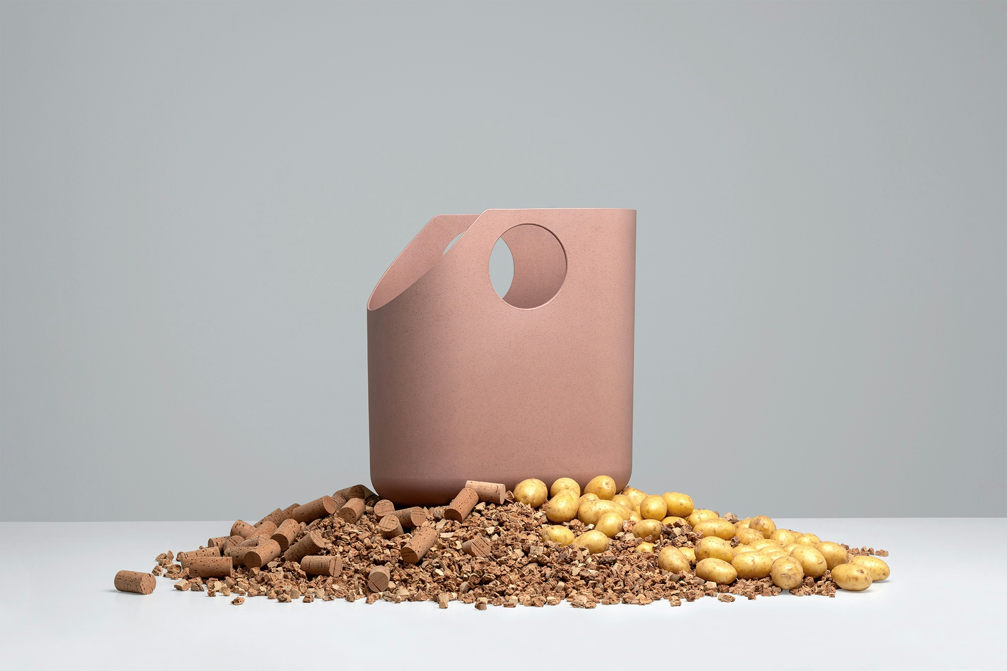 a design bag forming part of a modular storage system on a pile of cork and potatoes, representing the origin of its material
